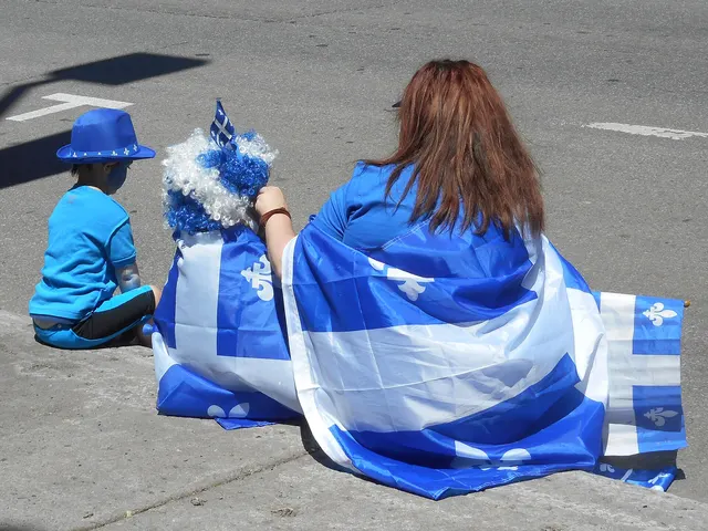 Spectateurs enveloppés dans le drapeau du Québec au bord d'un défilé de la Fête nationale
