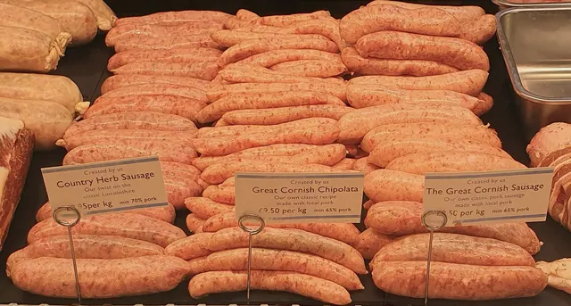 Saucisses maison alignées dans le comptoir d'une boucherie