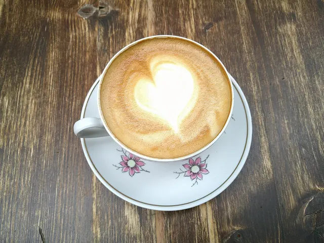 Cappuccino avec un cœur dessiné dans la mousse, sur une table en bois
