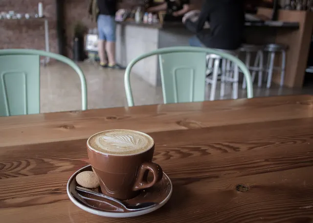Tasse de cappuccino sur un comptoir en bois dans un petit café