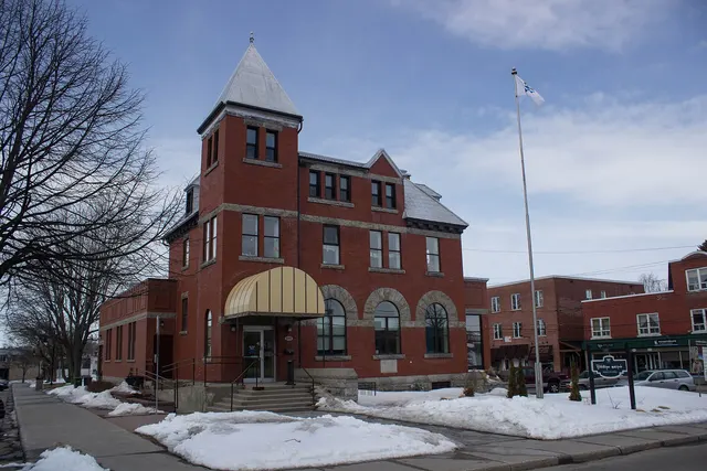 Bibliothèque municipale d'Acton Vale dans un édifice de brique à tourelle, au printemps