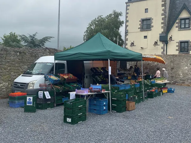 Étal de légumes sous une tente verte dans un marché fermier
