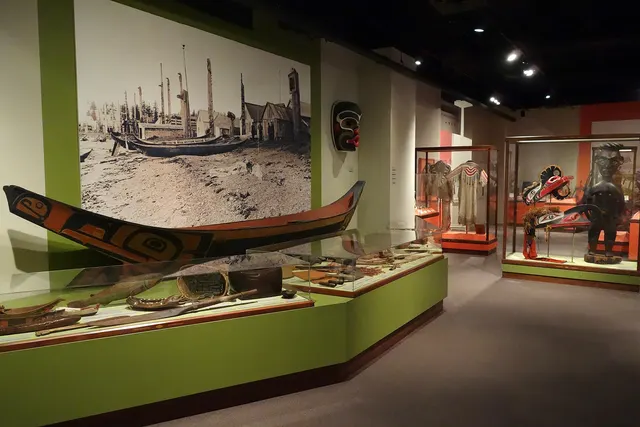 Salle d'exposition d'un musée avec un canot autochtone et des objets anciens