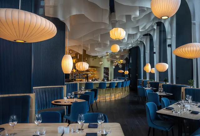 Salle de restaurant moderne aux banquettes bleues et lampes boules, place D'Youville à Québec