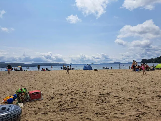 Grande plage de sable du lac Simon au centre touristique, avec des baigneurs au loin