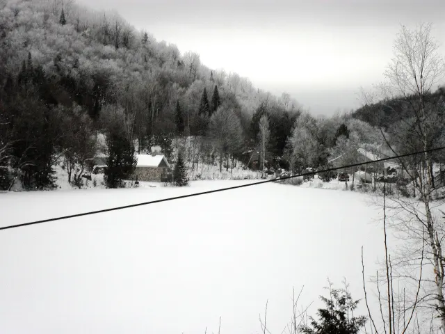 Rivière gelée et enneigée entre des collines givrées au nord de Lac-des-Plages