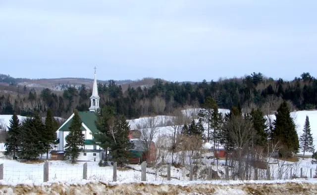 Le village de Mayo et son église au clocher blanc dans un paysage enneigé