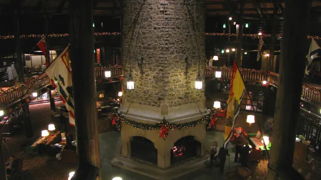 Le grand foyer hexagonal en pierre au centre du hall du Château Montebello, décoré pour les Fêtes