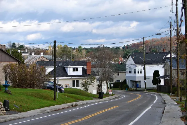 Rue en courbe de Saint-André-Avellin, maisons et collines d'automne