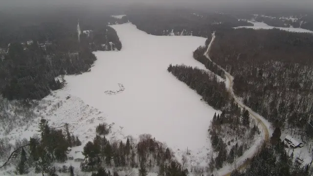Vue aérienne du lac Hacquard gelé et de la route qui le longe