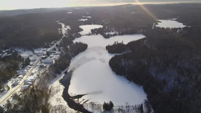 Vue aérienne du lac Saint-Émile gelé et du village sous la neige en décembre
